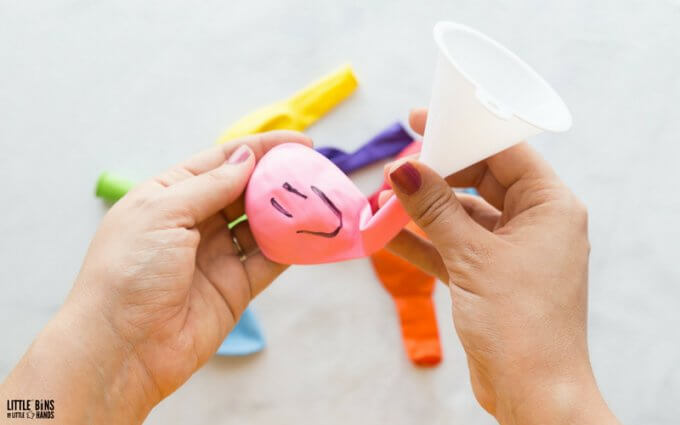 using funnel to fill balloon with baking soda for science activity