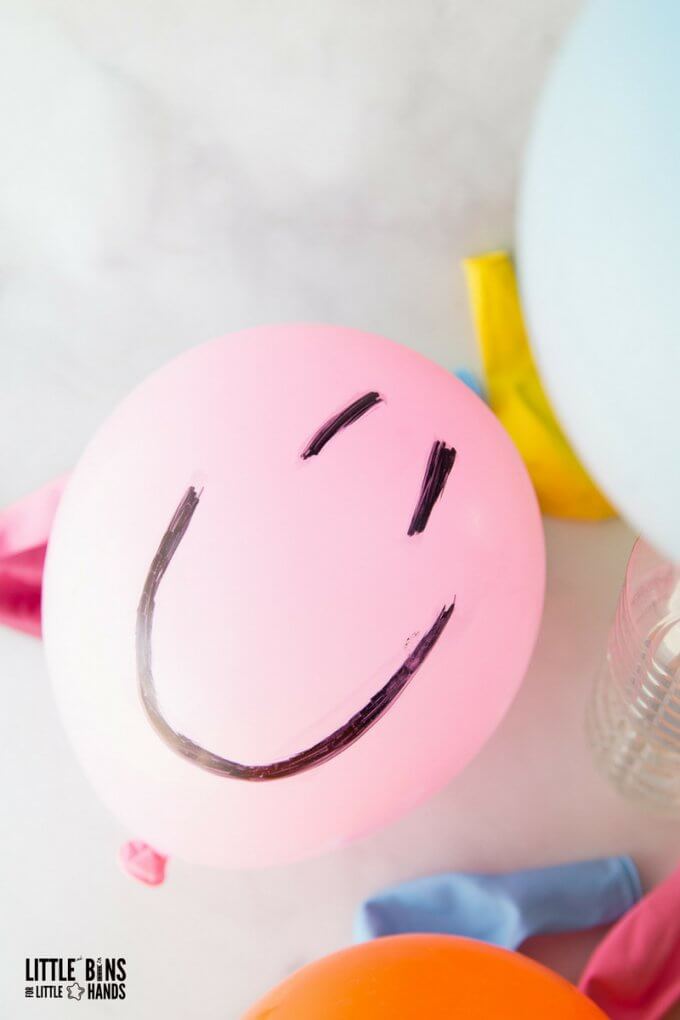 Balloon baking soda science with happy face drawn on pink balloon