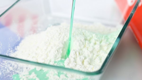 adding green water to cornstarch to make oobleck recipe